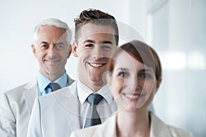 Smiling , friendly group of three businesspeople , and of different age private company staff posing for office portrait