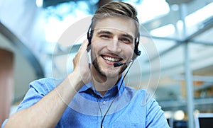 Smiling friendly handsome young male call centre operator.