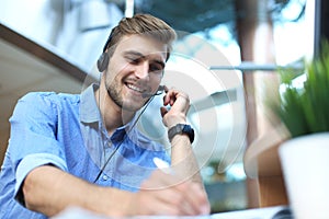 Smiling friendly handsome young male call centre operator.