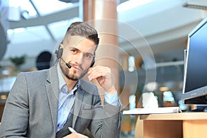 Smiling friendly handsome young male call centre operator.