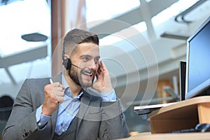 Smiling friendly handsome young male call centre operator.