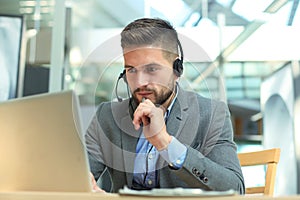 Smiling friendly handsome young male call centre operator.