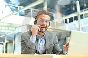 Smiling friendly handsome young male call centre operator.