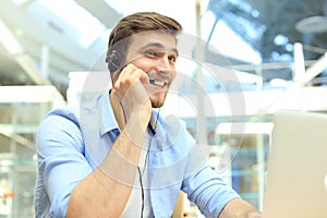 Smiling friendly handsome young male call centre operator