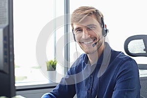 Smiling friendly handsome young male call centre operator