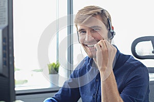 Smiling friendly handsome young male call centre operator