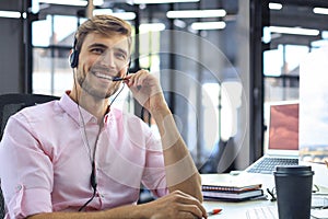 Smiling friendly handsome young male call centre operator.