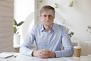 Smiling friendly millennial businessman sitting at workplace