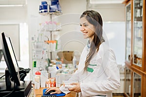 Smiling friendly pharmacist at the counter working in a pharmacy store. Pharmaceutical professional recommending an over the