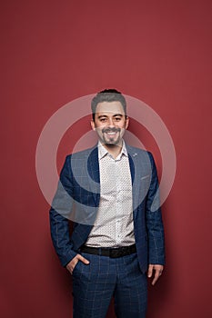 Smiling friendly professional man on red background portrait