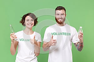 Smiling friends couple in volunteer t-shirt isolated on green background. Voluntary free work assistance help charity