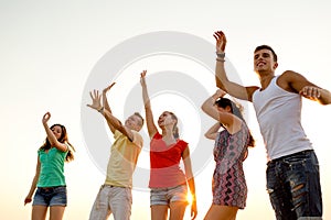 Smiling friends dancing on summer beach