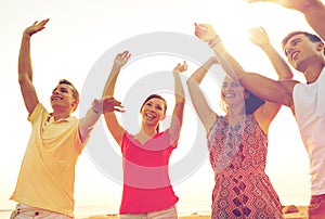 Smiling friends dancing on summer beach