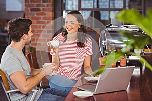 Smiling friends drinking coffee and chatting