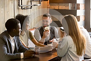 Smiling friends enjoying time together having coffee in cafe