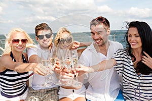 Smiling friends with glasses of champagne on yacht