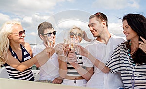 Smiling friends with glasses of champagne on yacht