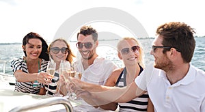 Smiling friends with glasses of champagne on yacht