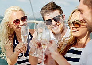 Smiling friends with glasses of champagne on yacht