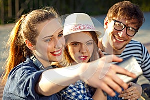 Smiling friends making selfie outdoors