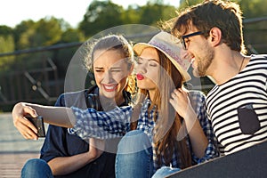 Smiling friends making selfie outdoors
