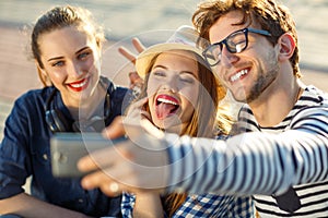 Smiling friends making selfie outdoors