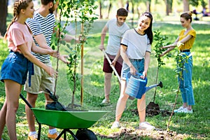 smiling friends planting new trees and volunteering