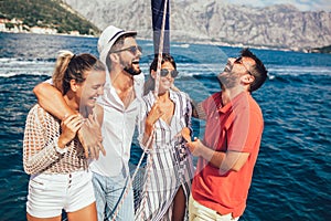 Smiling friends sailing on yacht.