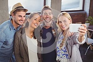 Smiling friends standing and taking selfies