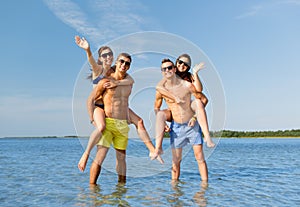 Smiling friends in sunglasses on summer beach