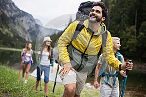 Smiling friends walking with backpacks. Adventure, travel, tourism, hike and people concept.