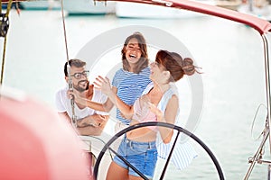 Smiling friends on a yacht enjoy bright sunny day on vacation