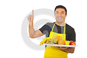 Smiling fruiterer pointing upwards