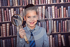 Smiling funny first-grader with a magnifying glass