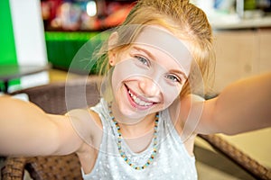 Smiling funny little girl doing selfie