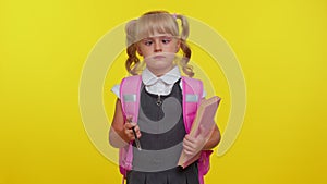 Smiling funny schoolgirl making humorous face with eyes crossed, playing fool, having fun, brainless photo