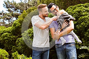 Smiling gay couple with child