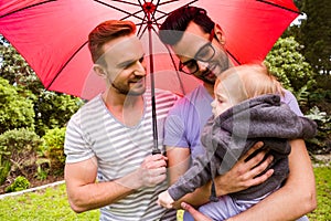 Smiling gay couple with child