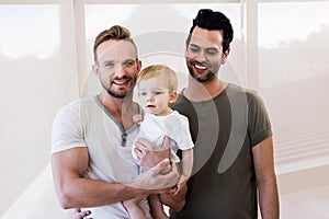 Smiling gay couple with child