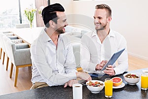 Smiling gay couple having breakfast