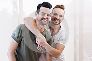 Smiling gay couple hugging