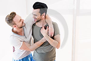 Smiling gay couple hugging