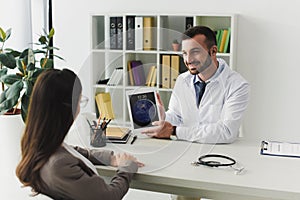 smiling general practitioner showing patient ipad
