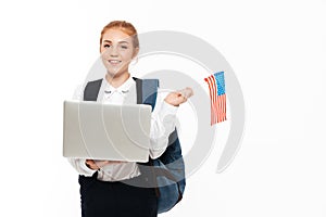 Smiling gigner student woman with backpack holding laptop computer