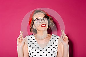 Smiling ginger woman in dress and eyeglasses praying