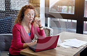 Smiling ginger woman talking per skype photo