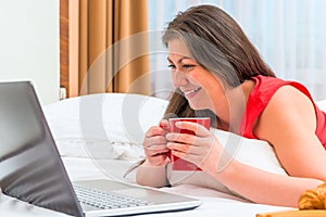 Smiling girl attentively looks at a laptop