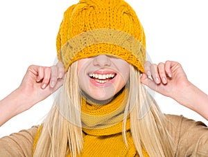 Smiling girl in autumn clothes with hat over head