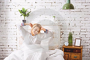 Smiling girl awakes in bedroom