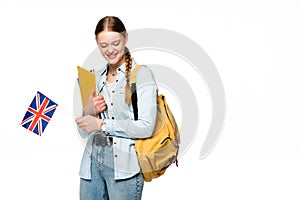 Smiling girl with backpack holding copybooks and uk flag